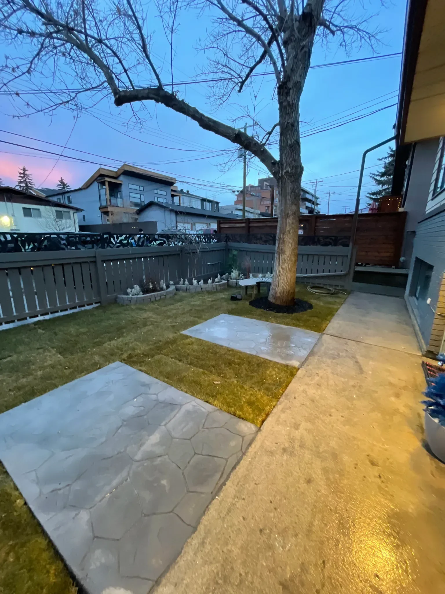 Stamped concrete patio and walkway featuring a decorative stone-pattern finish, seamlessly integrated into a backyard landscape. This project showcases durable, low-maintenance concrete surfaces designed to enhance outdoor living spaces in Calgary ho