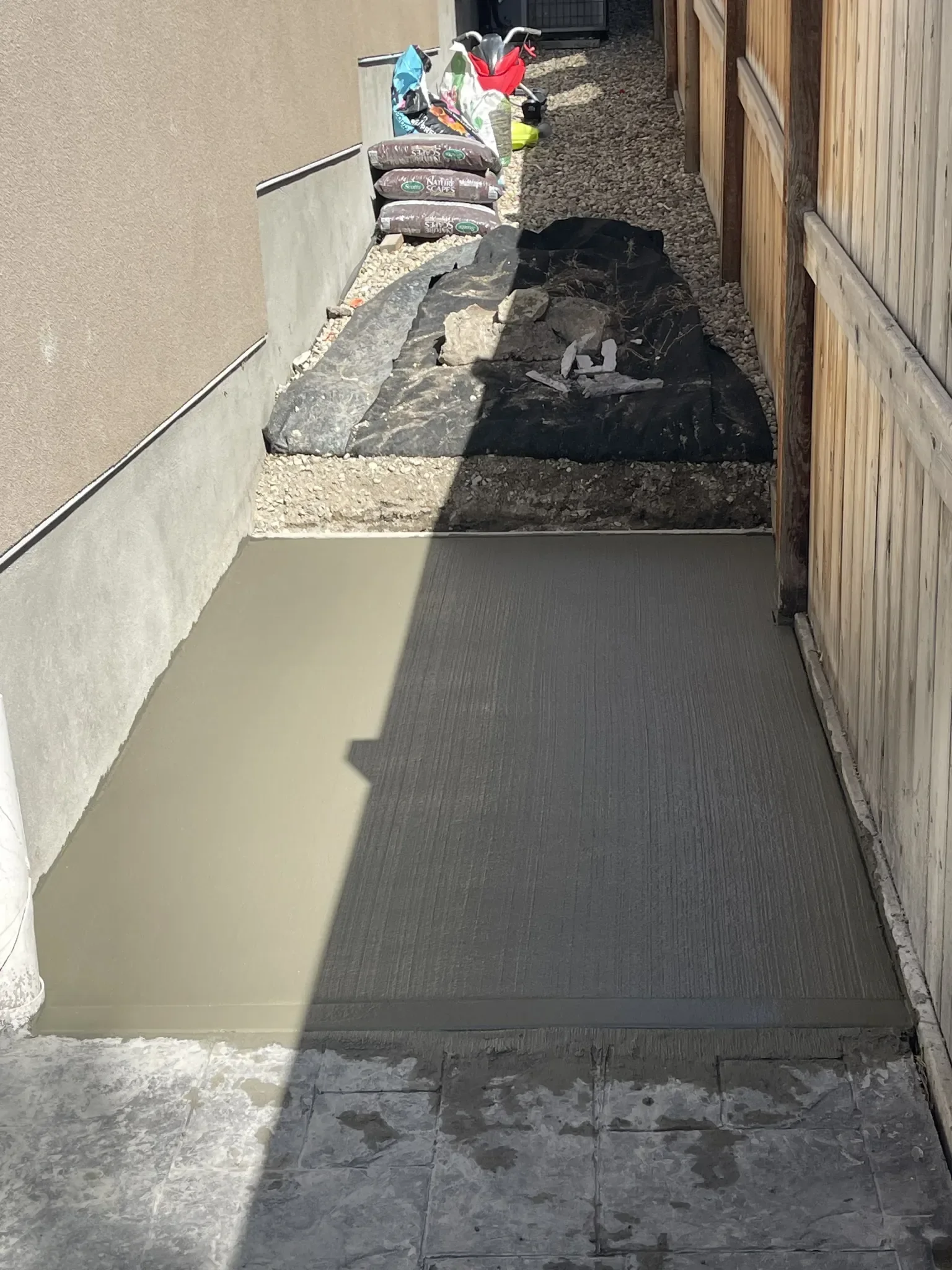 New concrete side yard walkway poured to replace gravel, improving accessibility, durability, and overall property appearance.
