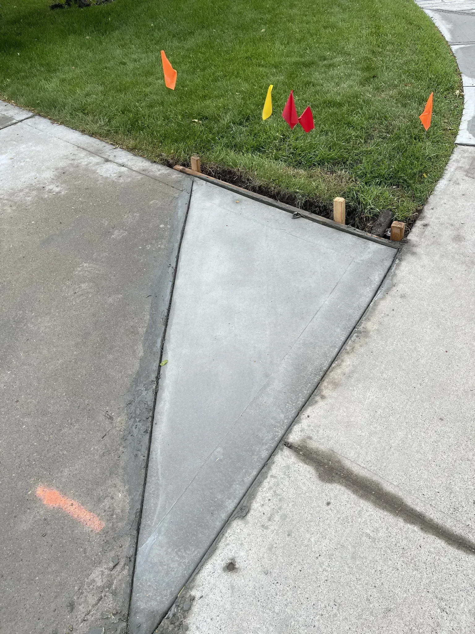 Finished concrete curb ramp poured to create a smooth transition between driveway and sidewalk, ensuring proper slope, accessibility, and long-term durability.