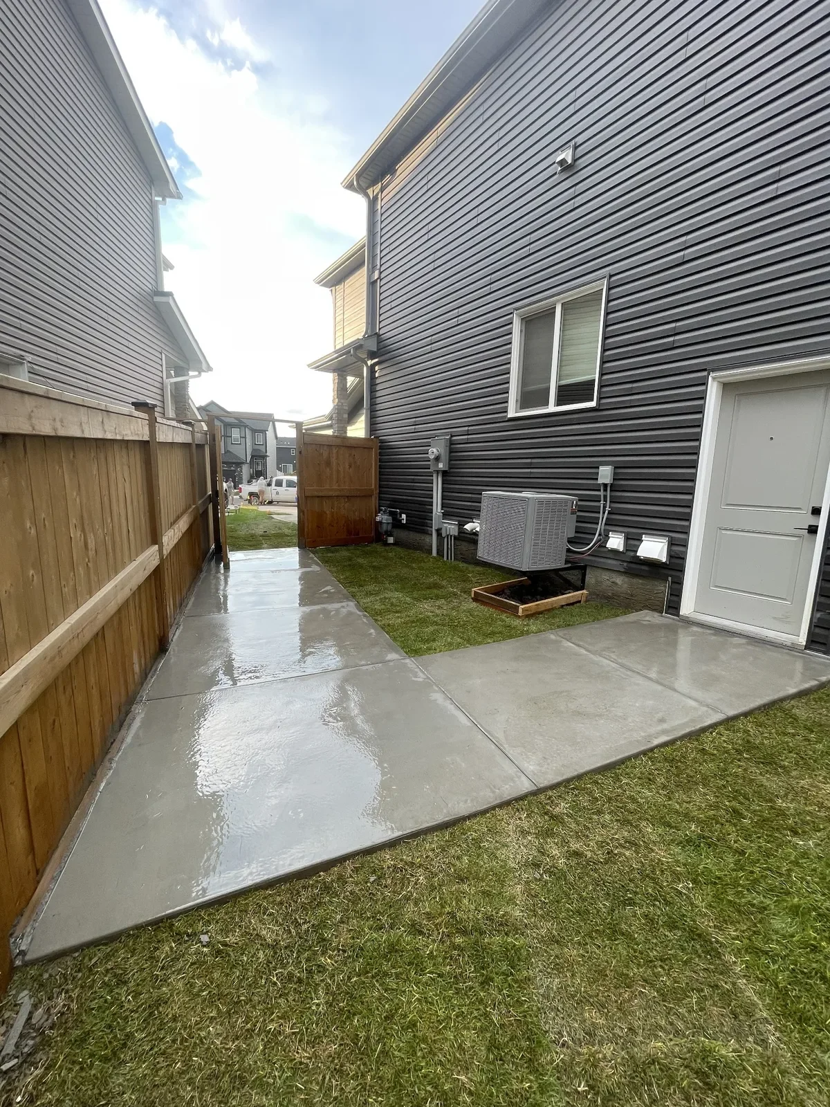 Concrete sidewalk and walkway installation beside a residential home in Calgary