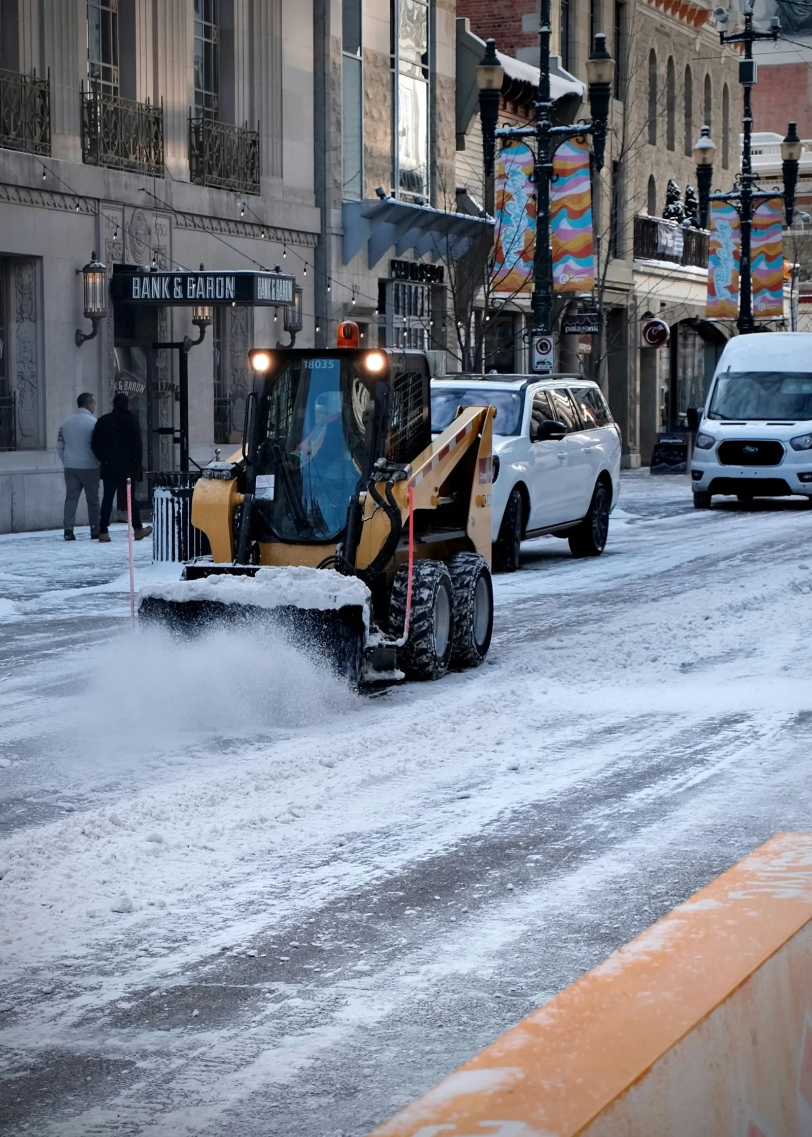 Snow removal equipment clearing snow from a downtown Calgary street during winter