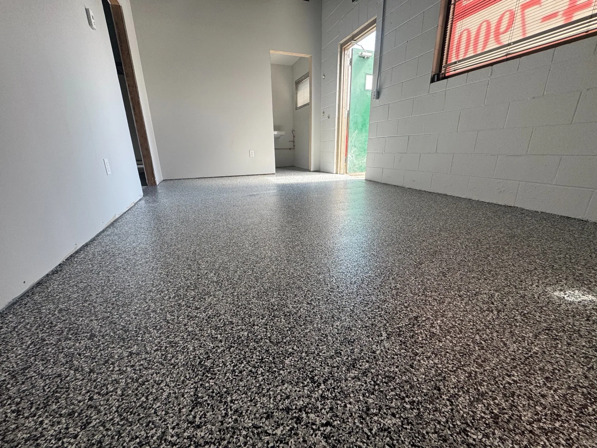 Durable commercial epoxy flooring with a grey flake finish, providing a clean, slip-resistant surface for high-traffic spaces.