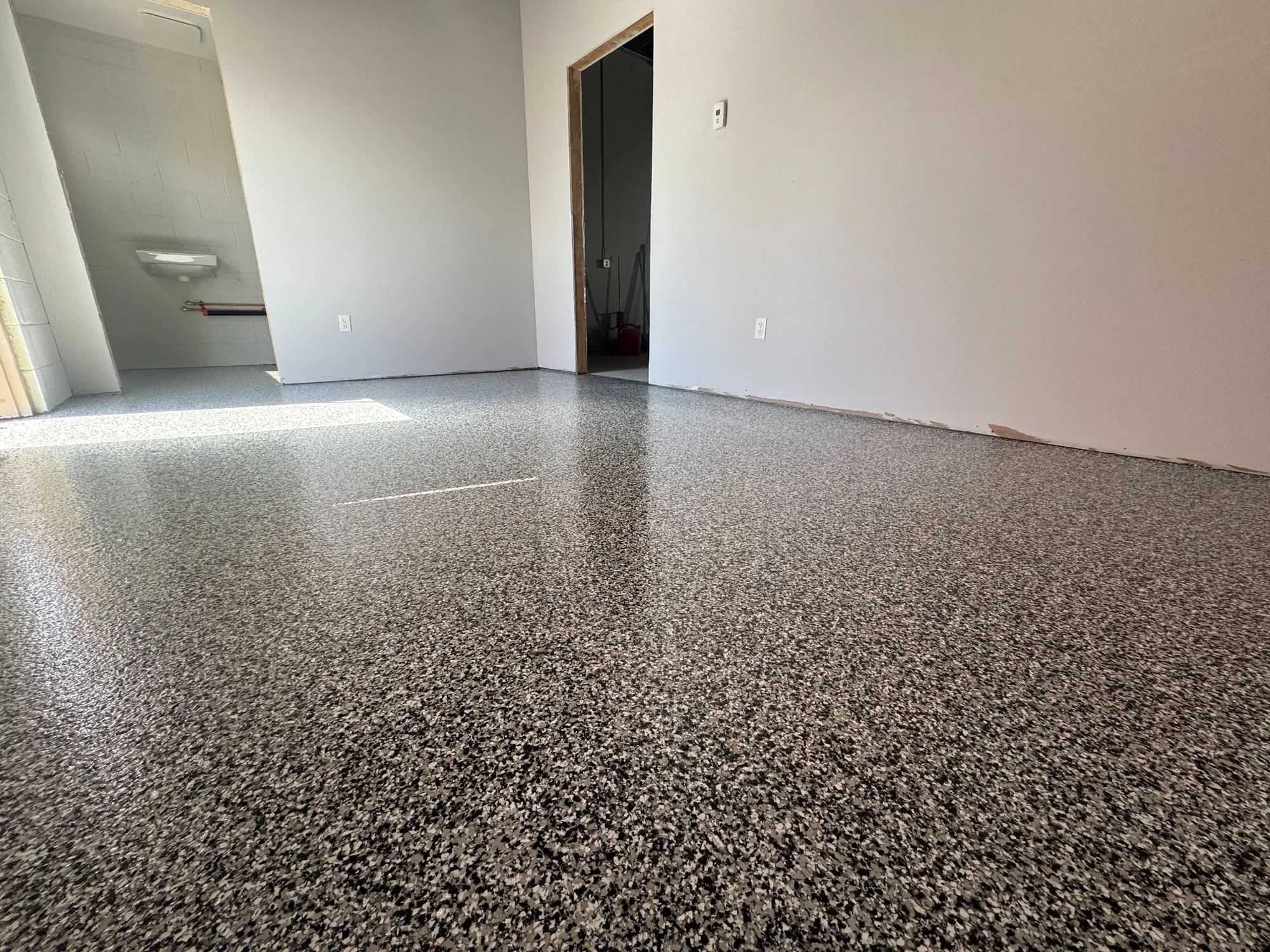 Interior commercial room finished with a durable grey flake epoxy floor, offering a seamless, low-maintenance surface.