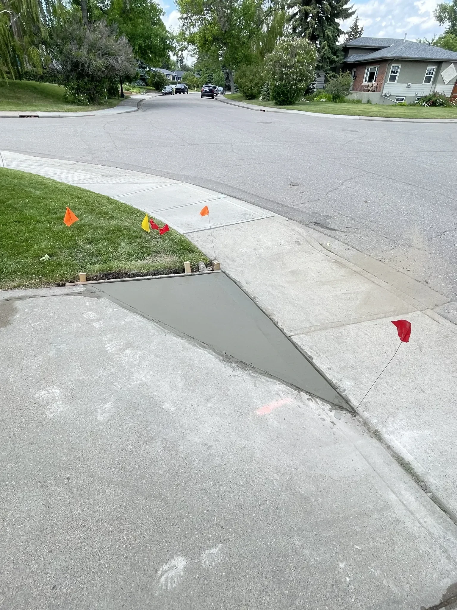 Concrete curb ramp repair completed to improve accessibility and ensure proper slope and water drainage, seamlessly blending with existing sidewalk sections.