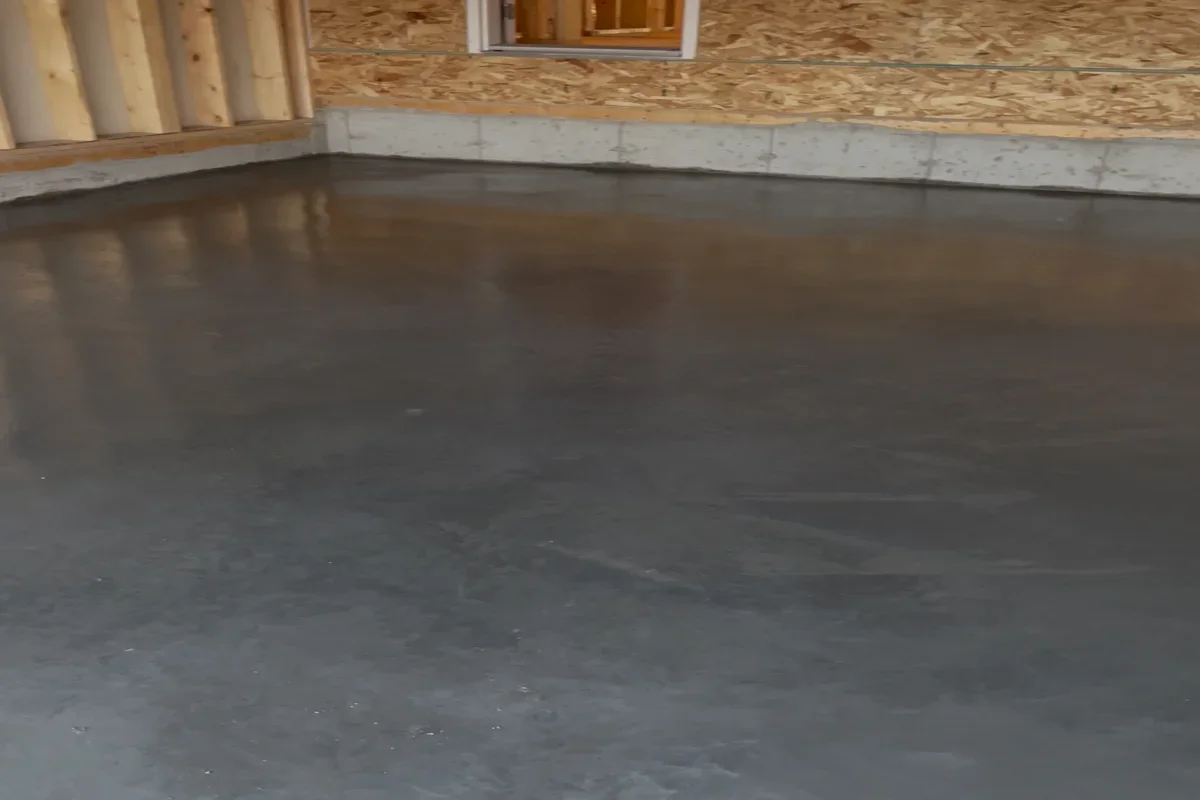 Freshly poured concrete garage pad with smooth finish inside a residential garage in Calgary