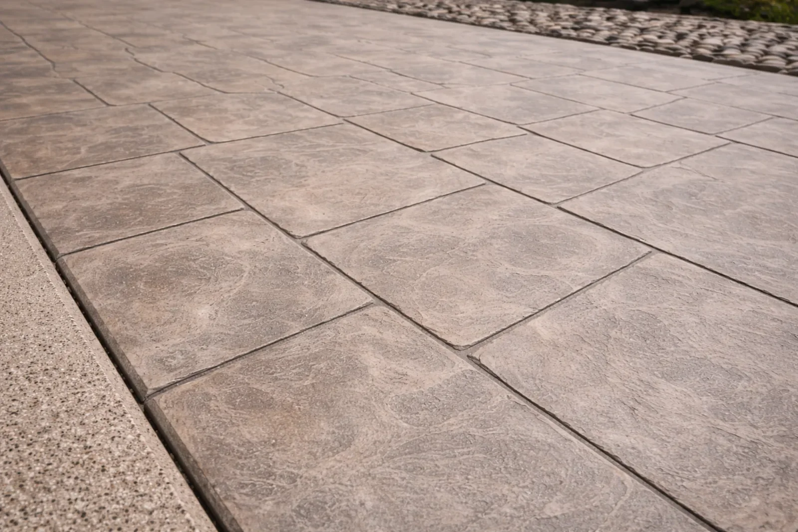 Custom Italian finish concrete driveway with textured stone pattern and refined decorative surface in Calgary