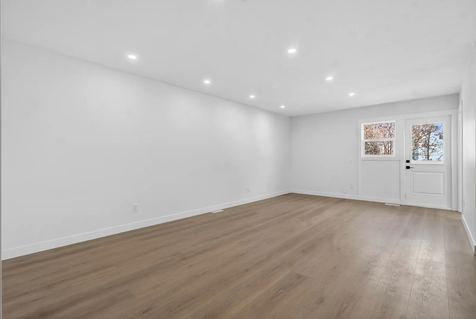 Completed full home renovation featuring a clean, modern interior with smooth white walls, recessed ceiling lighting, and warm wood flooring. Designed for a bright, open, and contemporary living space.