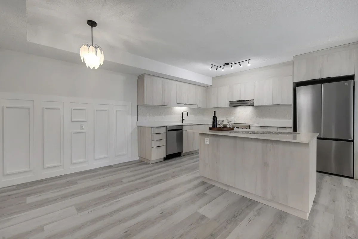 Open-concept kitchen and dining room renovation in Calgary with custom cabinetry, quartz countertops, stainless steel appliances, luxury vinyl plank flooring, and premium modern finishes completed by Da Vinci Contracting.