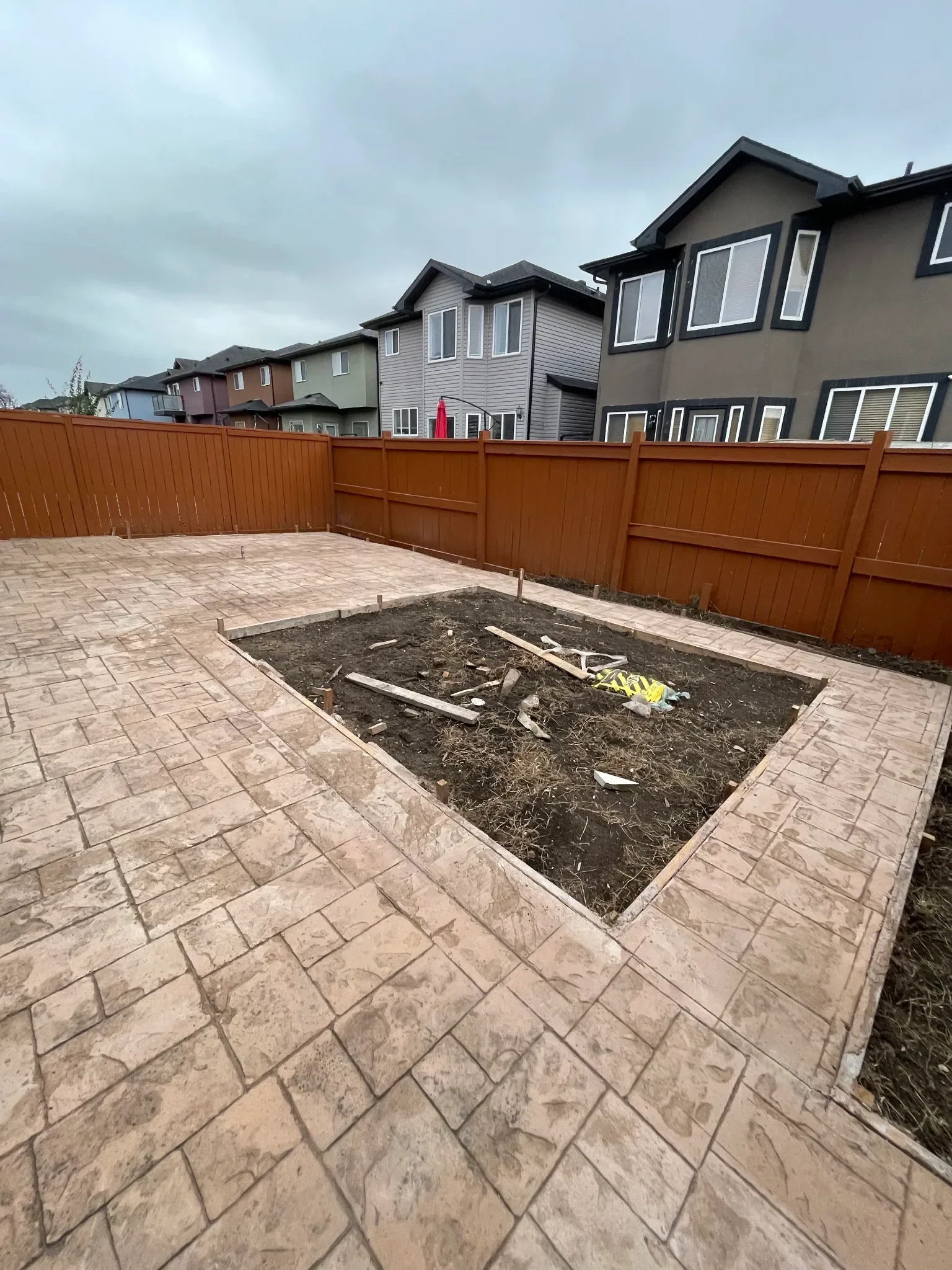 Stamped concrete backyard patio featuring a decorative stone-pattern finish, creating a durable and visually appealing outdoor living space. Designed for long-term performance and style, this patio enhances functionality while complementing Calgary r
