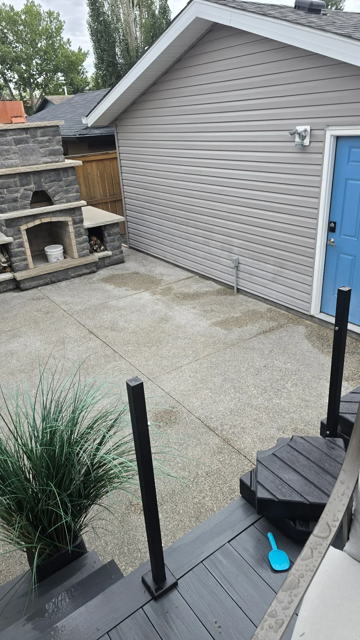 Spacious concrete back patio featuring a durable exposed aggregate finish, designed for outdoor entertaining and seamless connection to the home and backyard.
