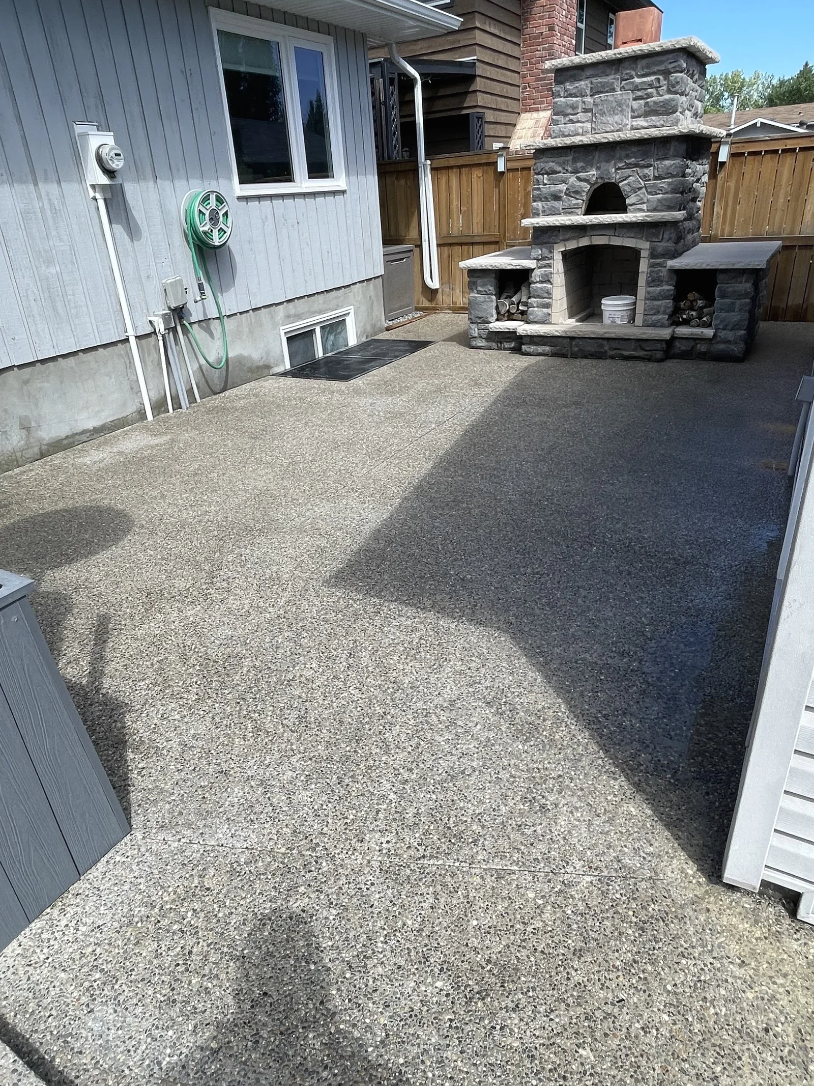Exposed aggregate concrete patio with outdoor fireplace in Calgary.