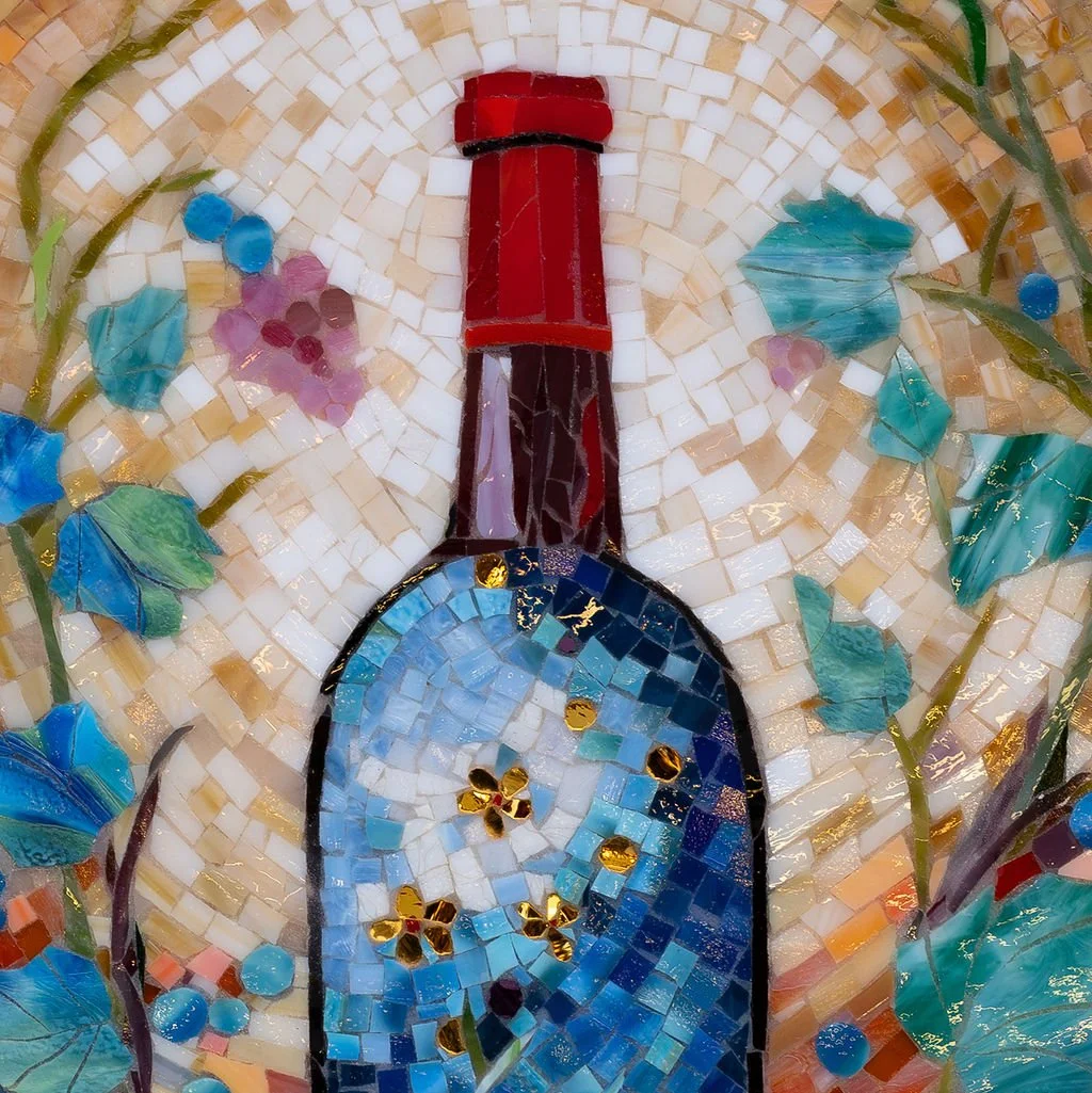 Mosaic artwork of a perfume bottle with blue, purple, red, and gold glass tiles, surrounded by floral and vine patterns.
