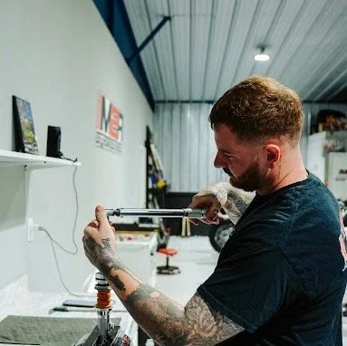A tech uses a torque wrench on a shock at M2R OffRoad Suspension.