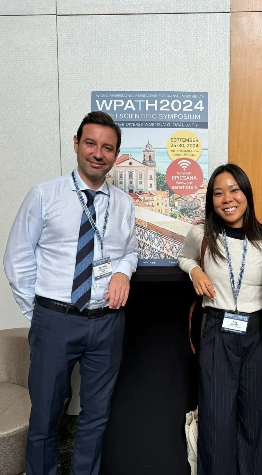 Two people wearing conference badges standing next to a poster at the World Professional Association for Transgender Health WPATH2024 symposium in Lisbon, Portugal, September 25-30, 2024.