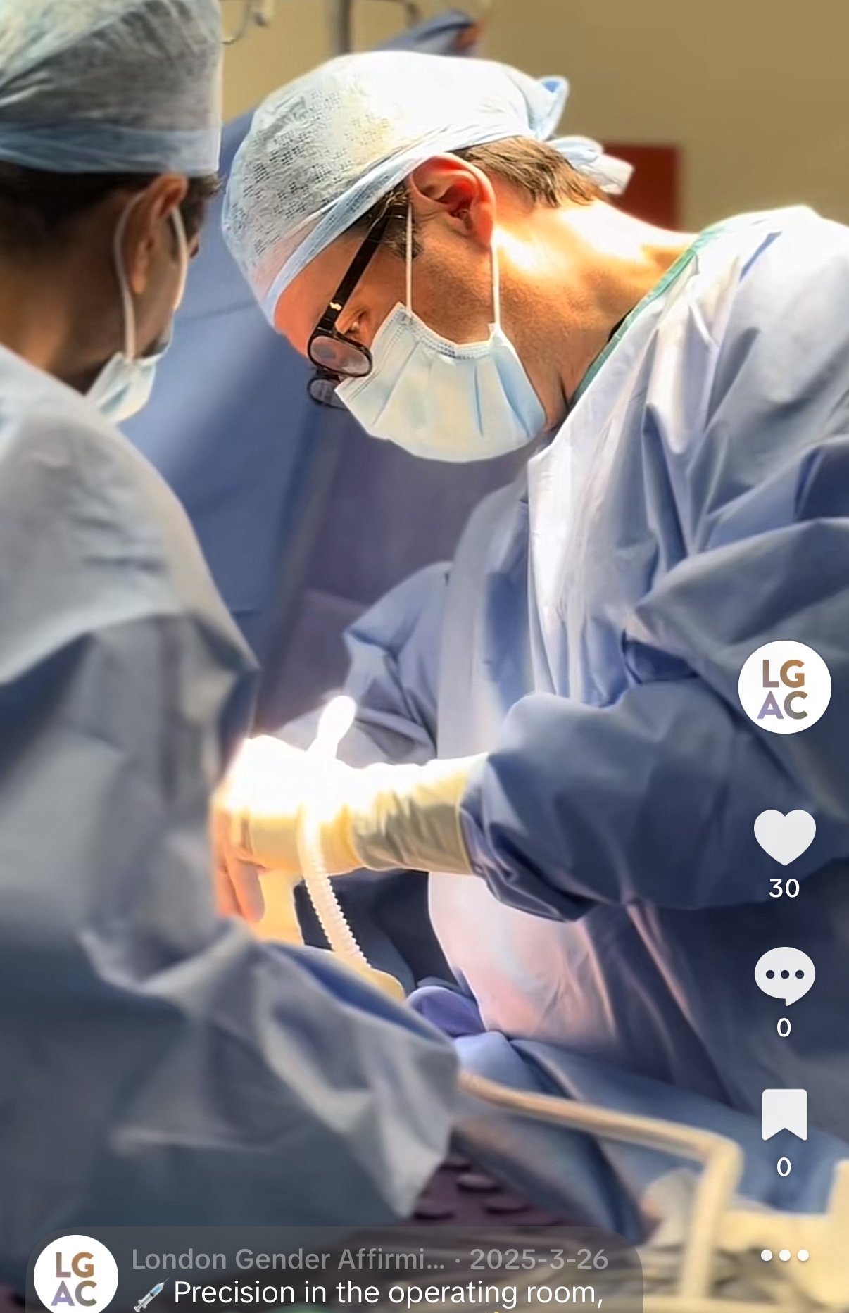 Two surgeons in surgical attire, including masks, gloves, and caps, perform an operation in a sterile operating room.