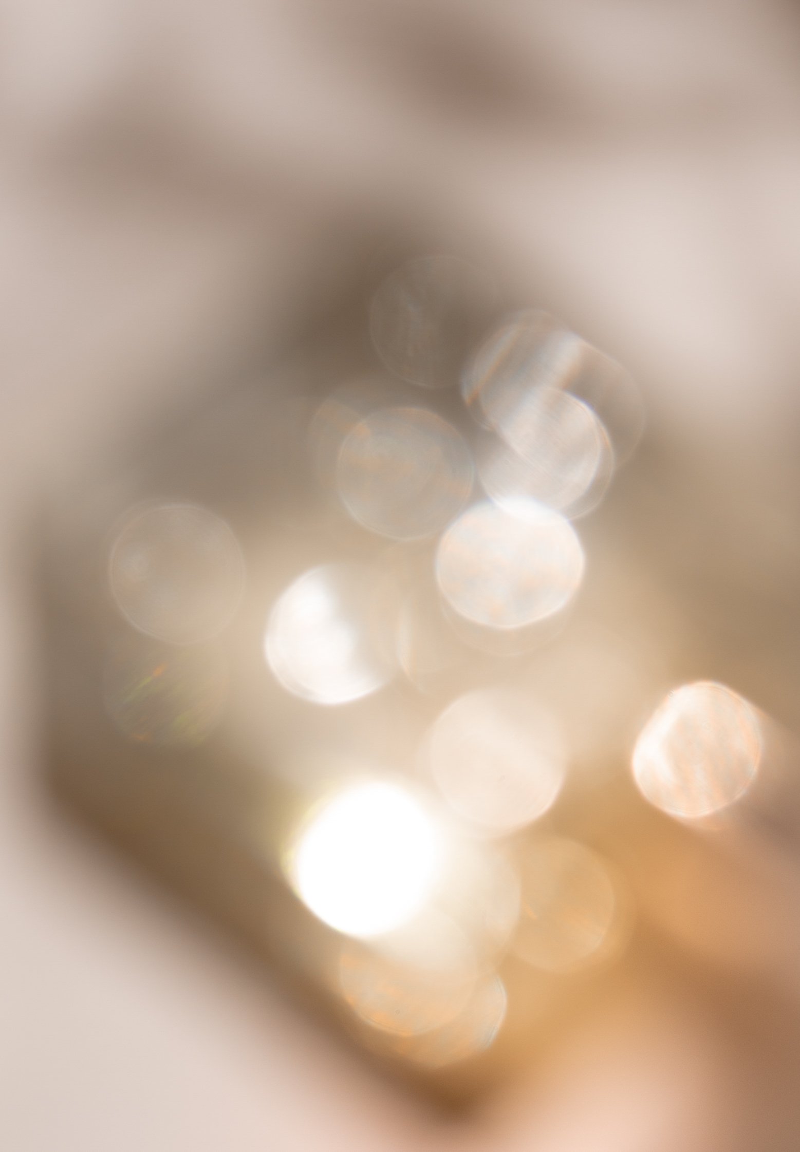 Blurred close-up of sparkling, reflective surfaces creating bokeh effect with bright circles of light.