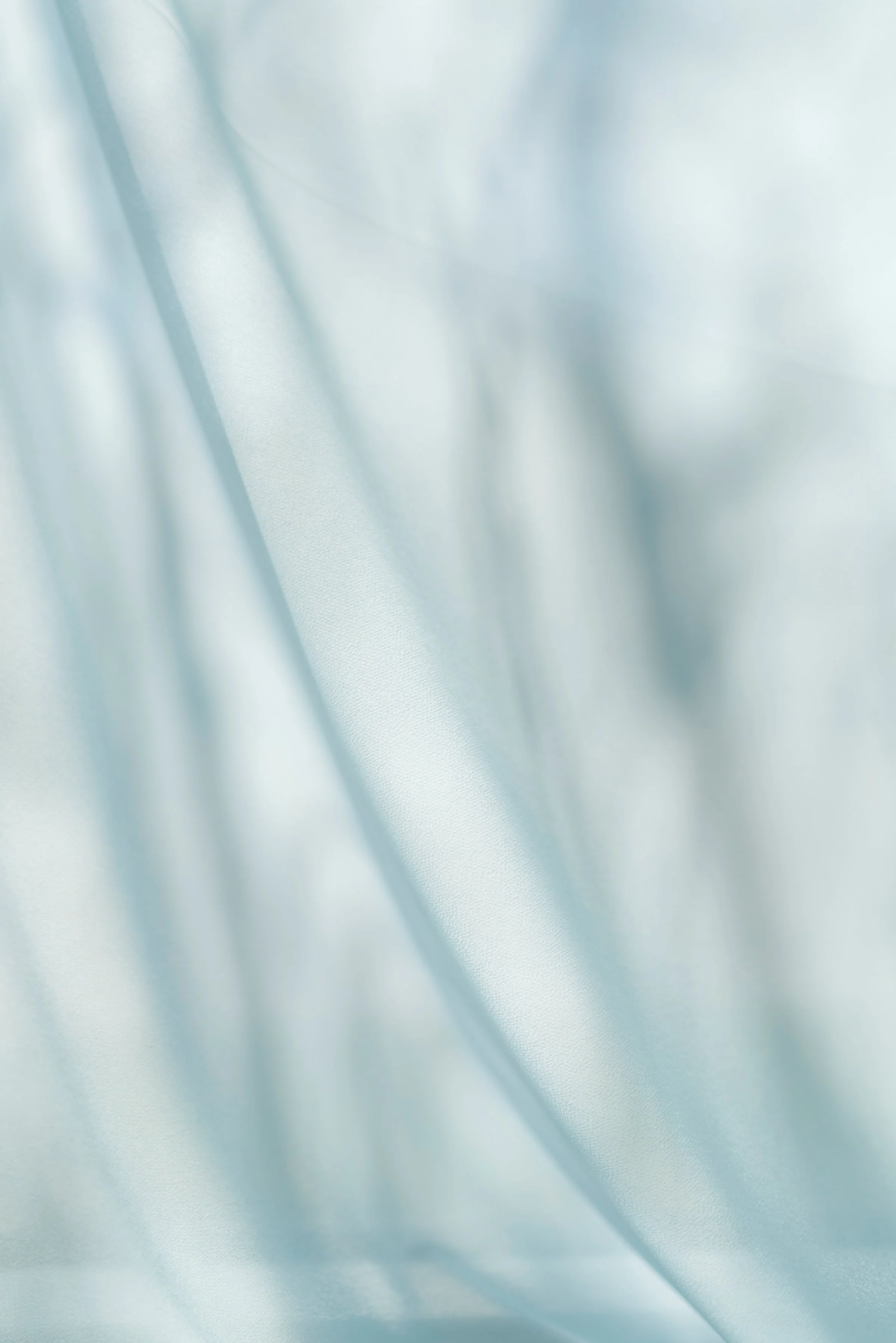 Light blue satin fabric with soft folds and gentle sheen.