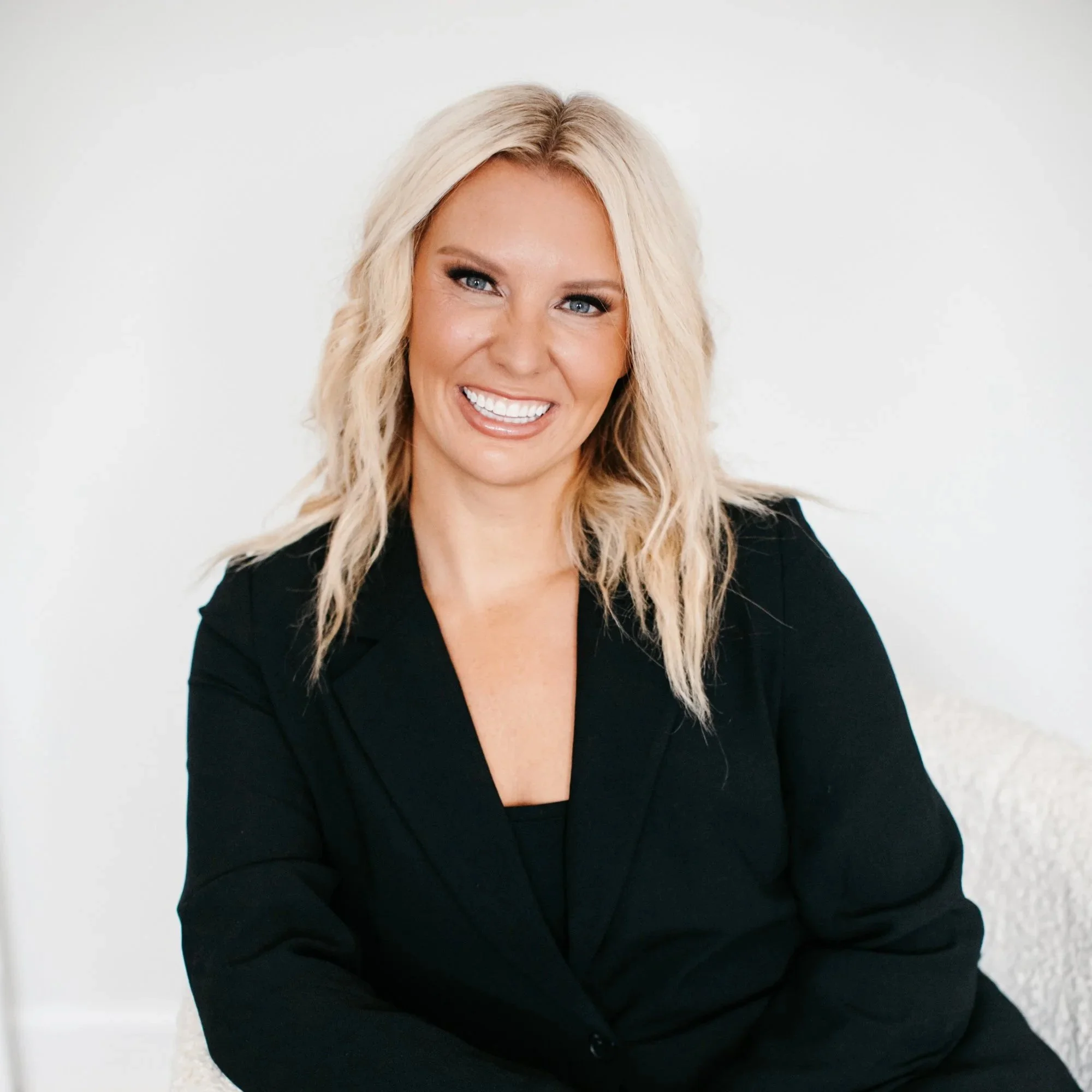 Dr. Audra Lance, wearing a black blazer, sitting against a plain white background.