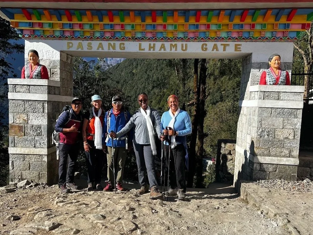 woman adn men group photo in front of pasang lhamu gate in lukla nepl