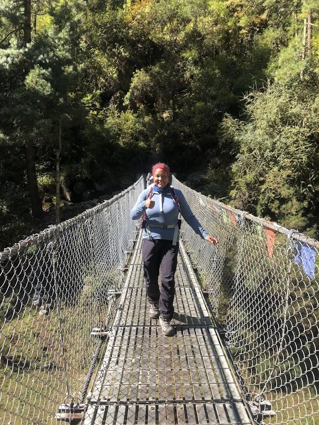 woman hiker on wire bridge in himalayas