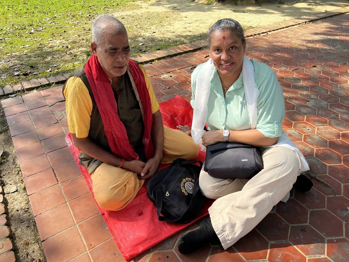 woman on ground with monk getting a blessing in nepal