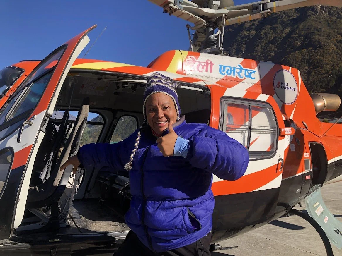 woman hiker in lukla by helicopter smiling thumbs up