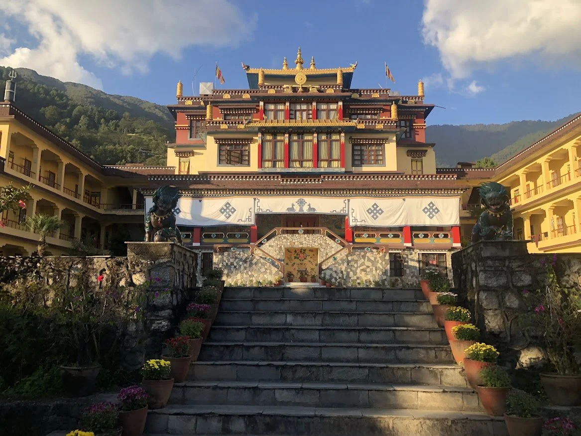 monastary in nepal up stairs in mountains with blue sky an some clouds