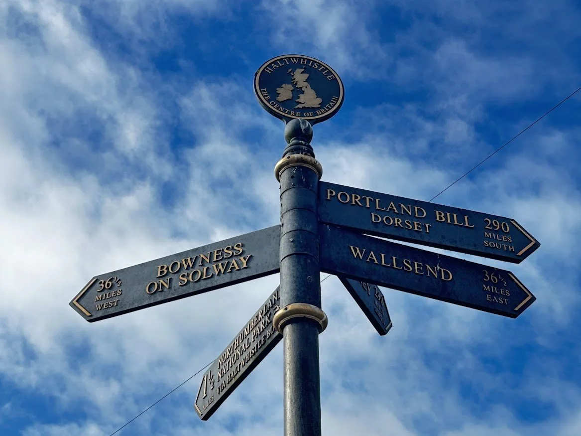 signport for thecentre of england haltwhistle against blue skies