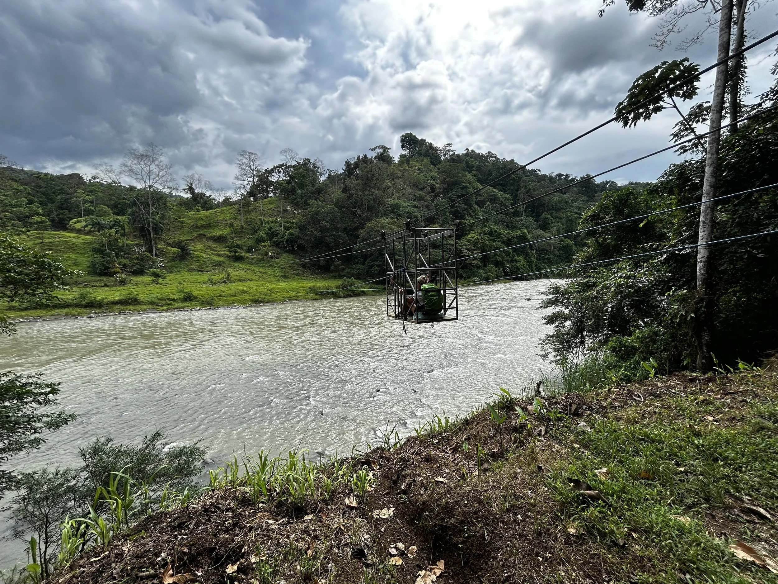 cage over riverbank transport costa rica camino cloudy sky