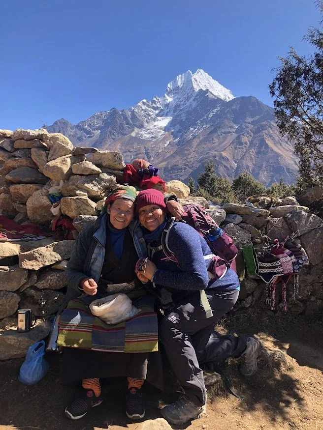 woman on himalayan mountain trail with old woman selling products