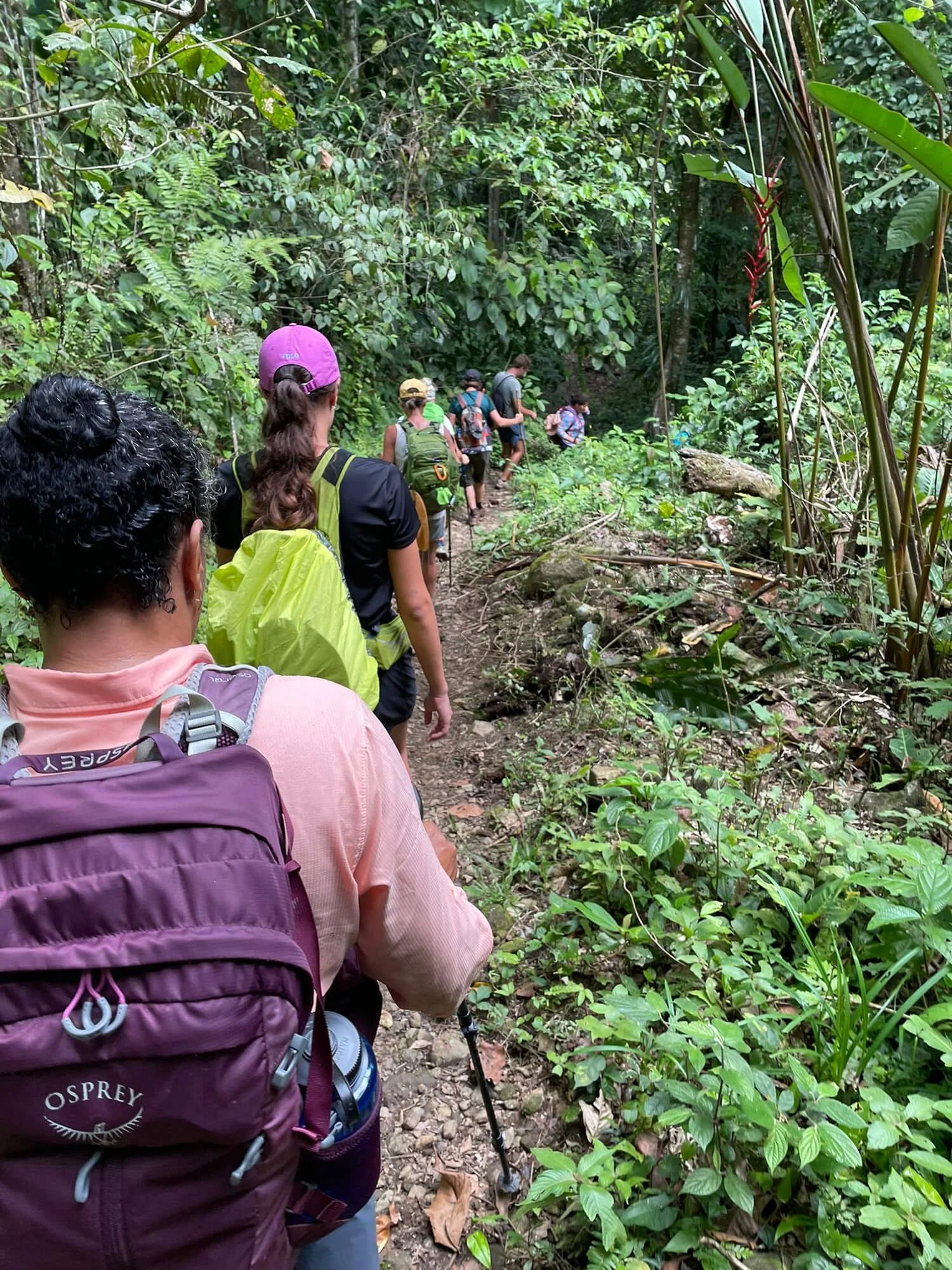women hiking camino de costa rica trail in lush forest with osprey backpack