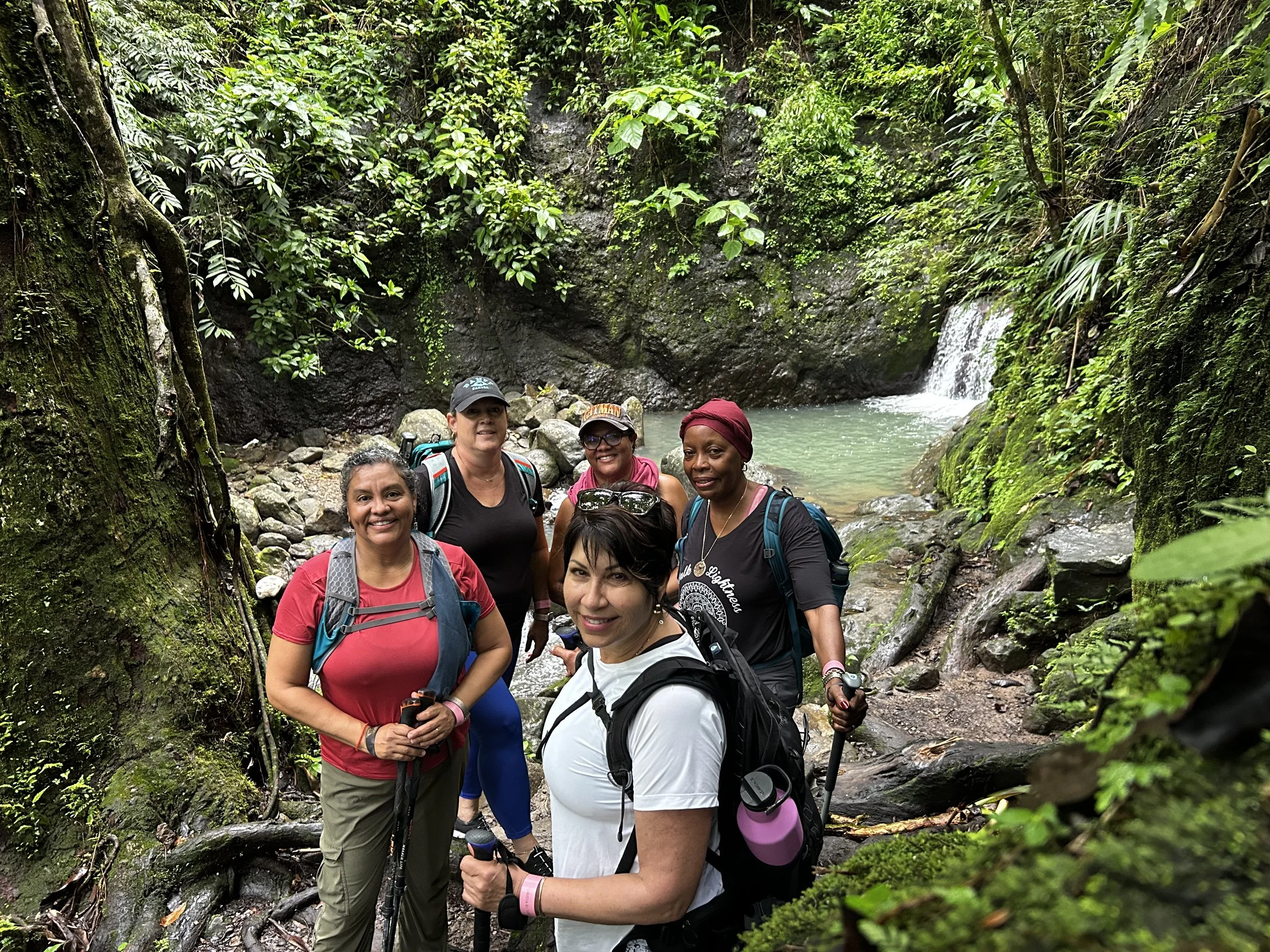 happy women hiking to waterfall