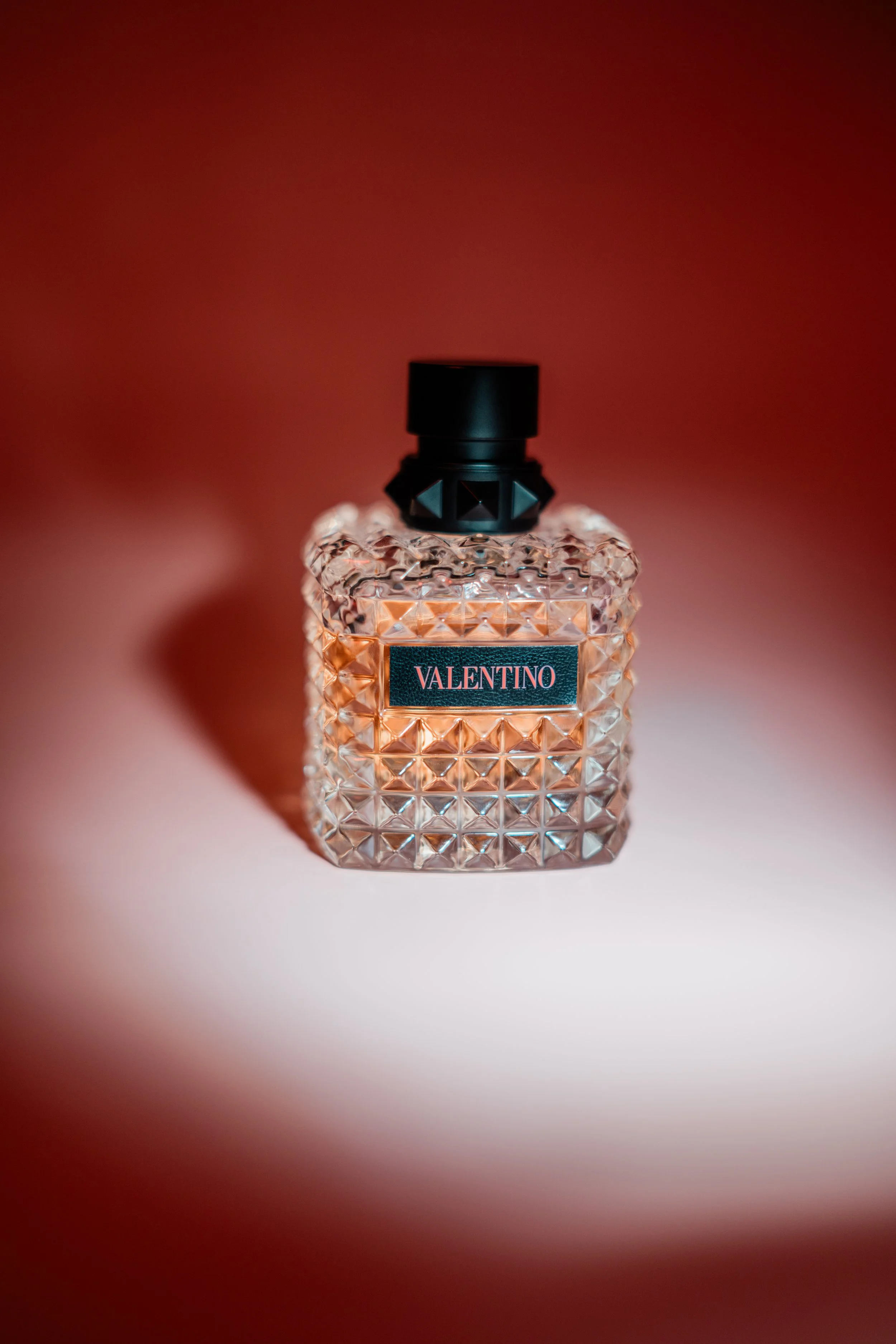 High-end product photography for Valentino perfume, creative lighting setup for cosmetic brand content.