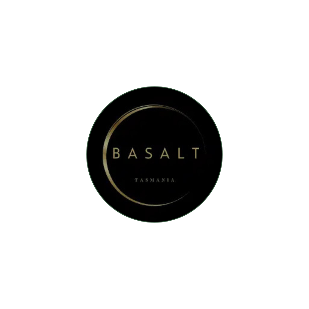 A circular logo with a black background and gold border, featuring the text 'BASALT' and 'TASMANIA' in gold.