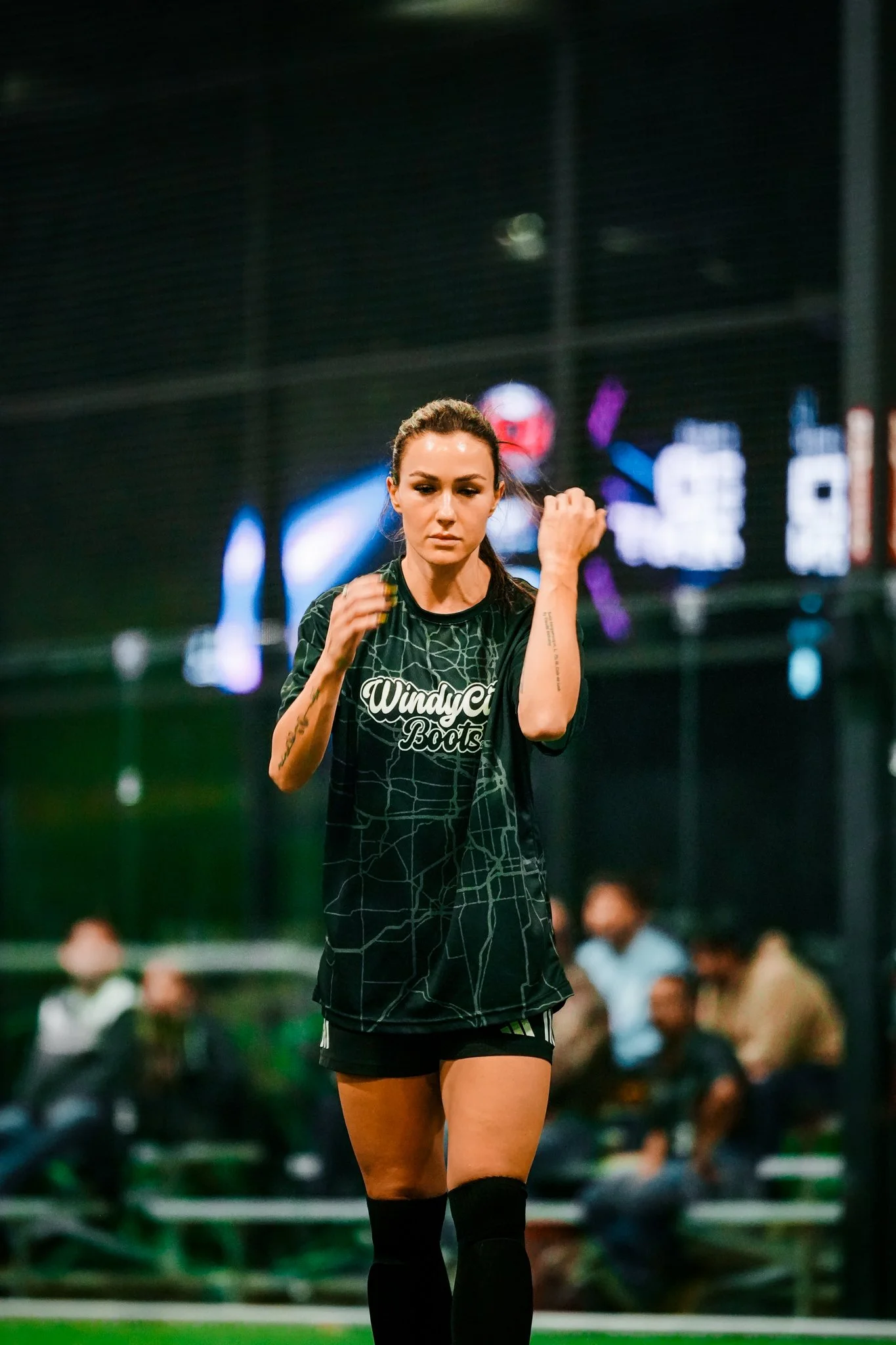 A female soccer player wearing a black uniform with