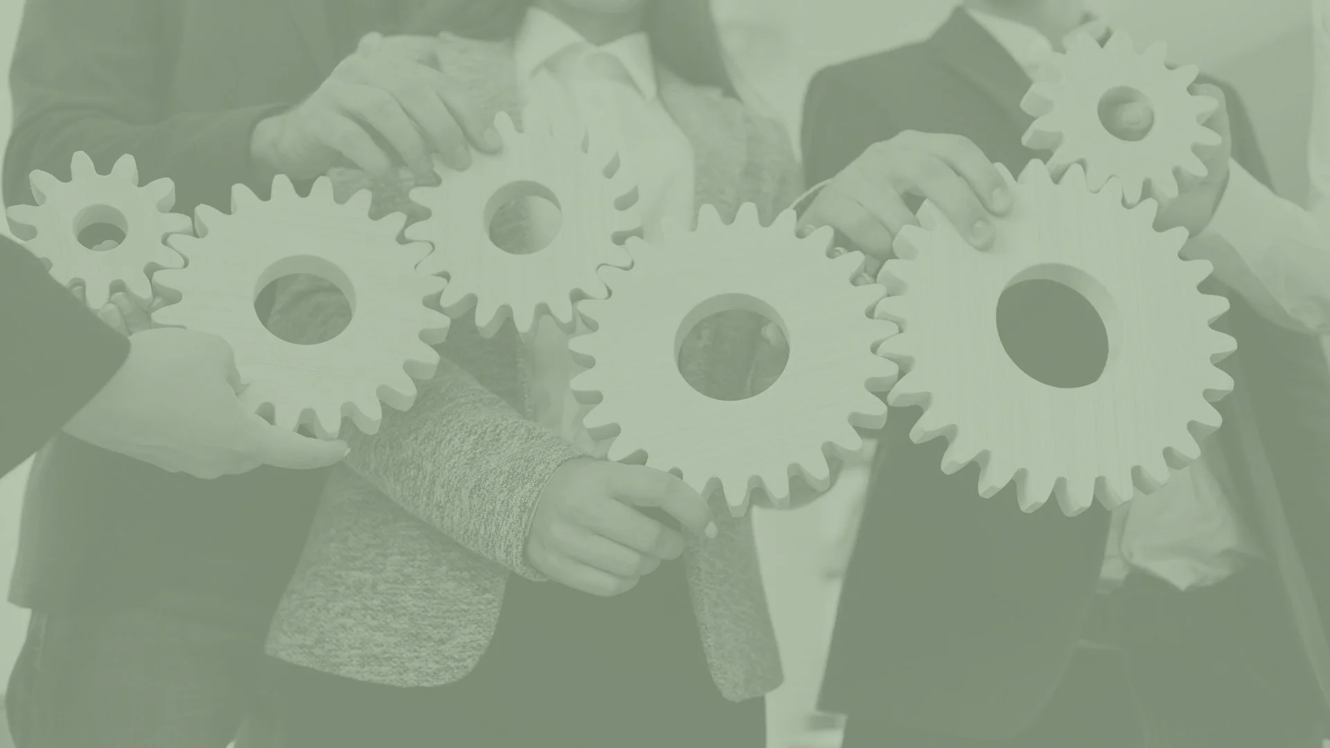 People holding large interlocking gears during a collaborative activity.