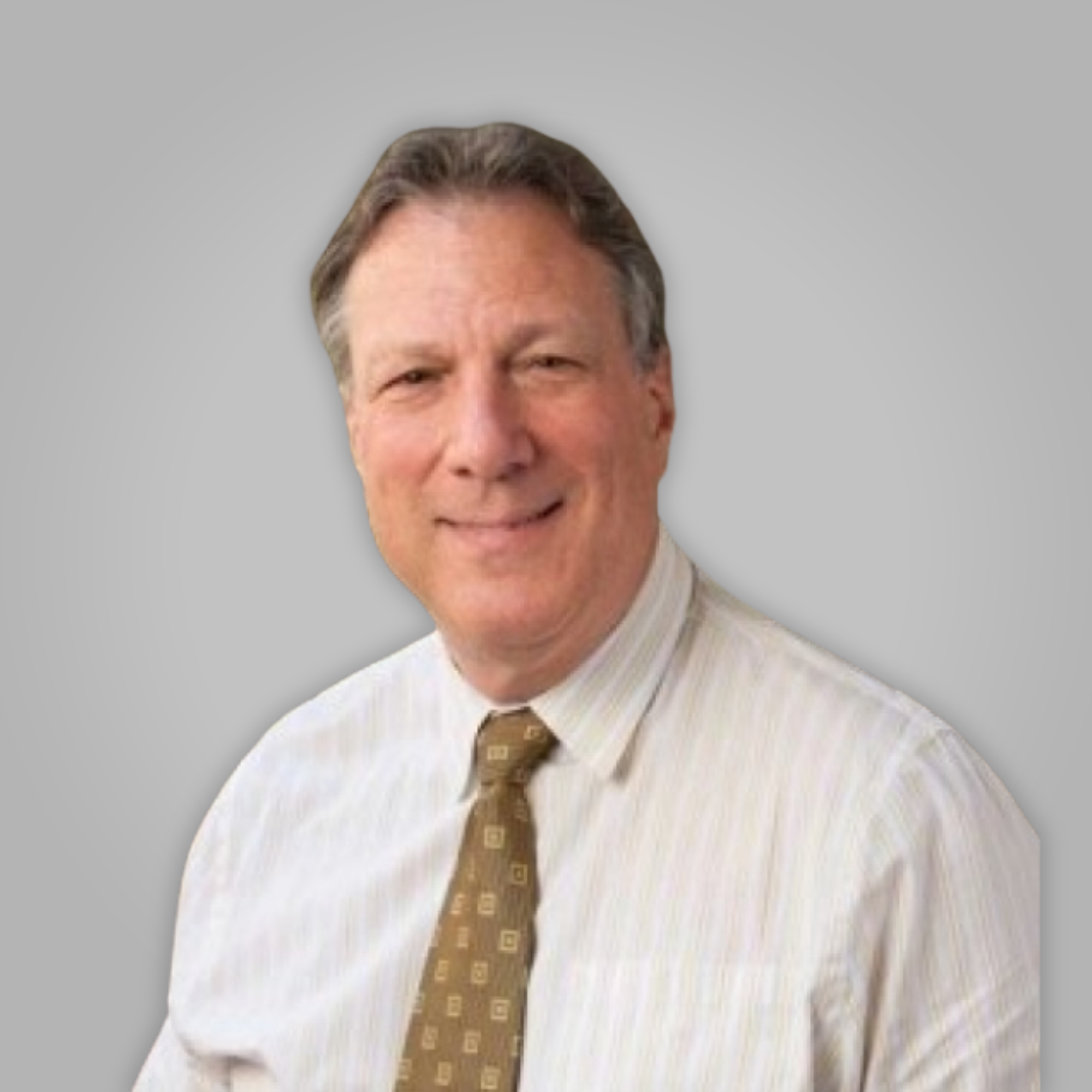 Close-up of a smiling man wearing a beige striped suit, a white shirt, and a patterned brown tie, against a plain light gray background.
