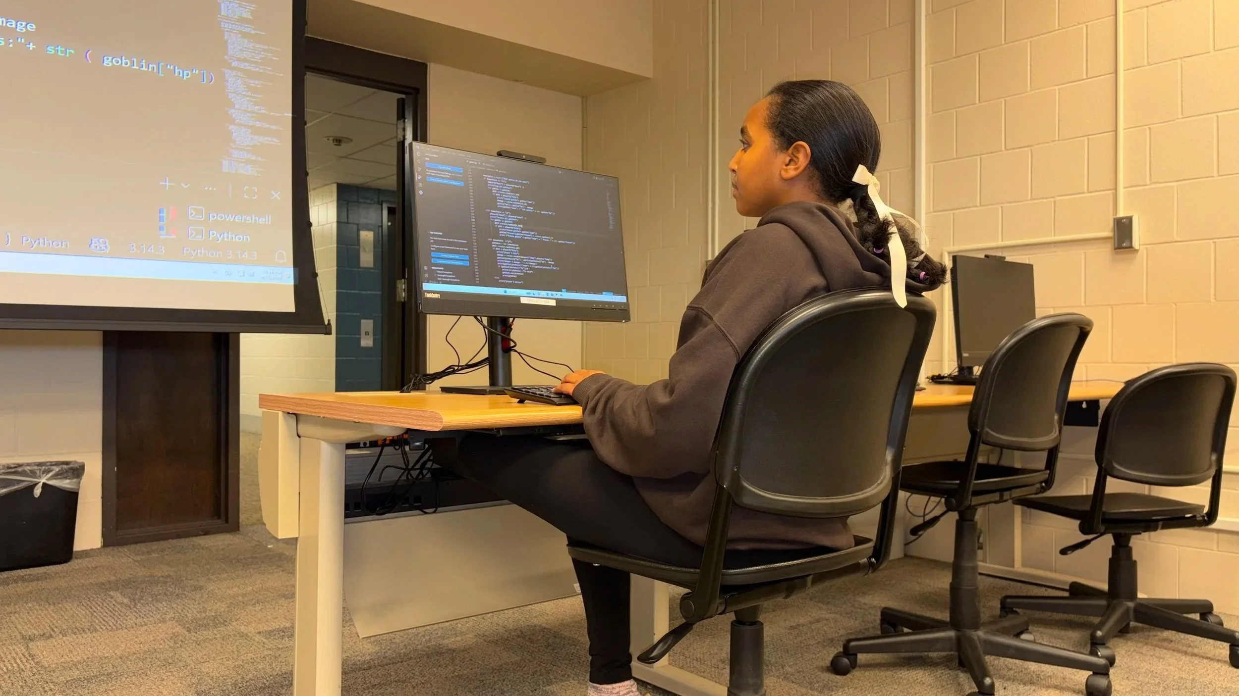 middle school girl working on coding on a computer