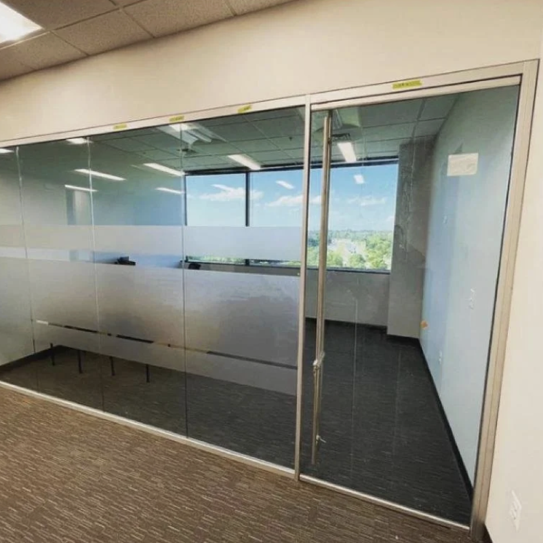 Empty office conference room with glass walls and a modern view of the city outside.