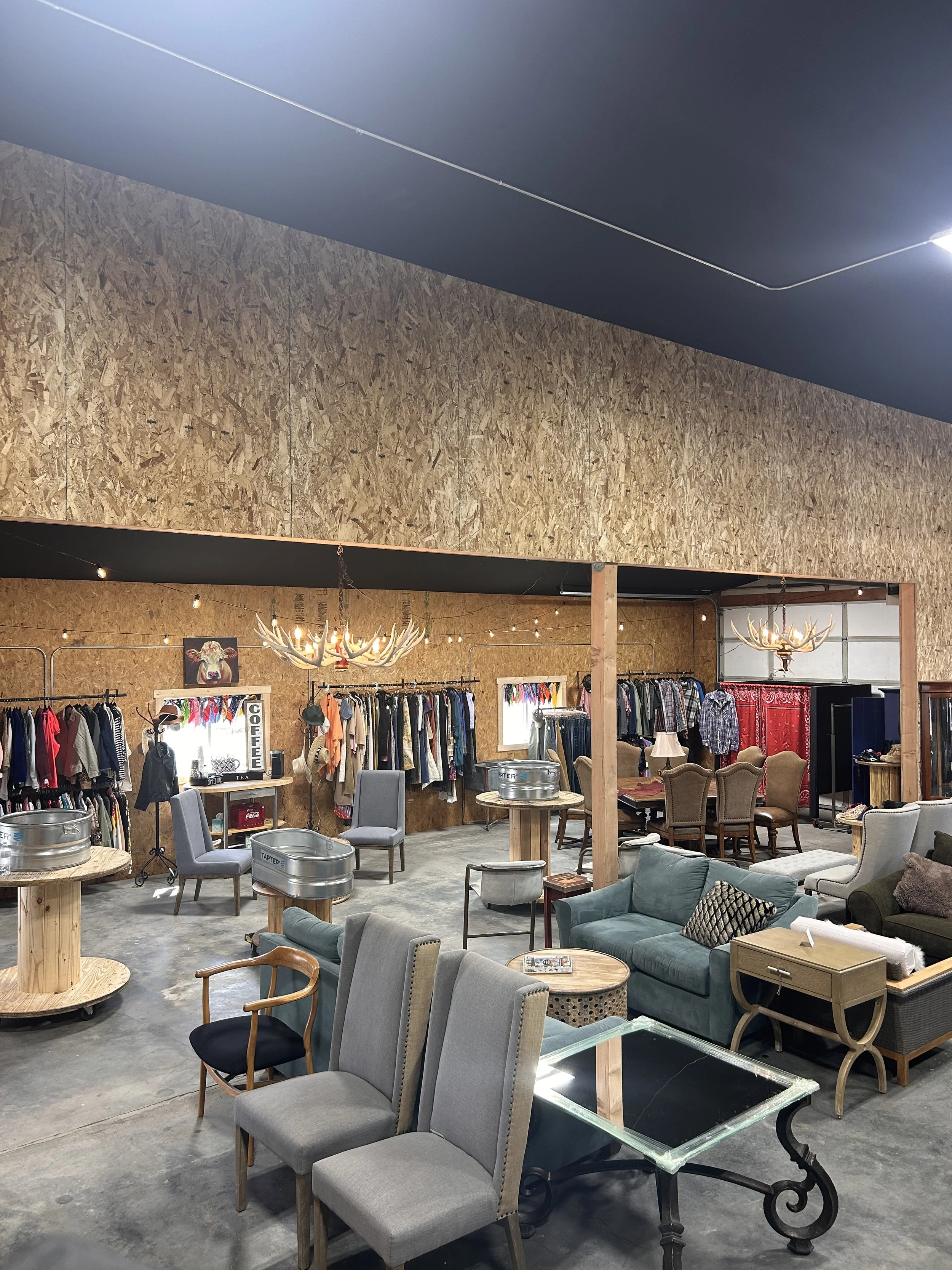Up high view of the ReStore ReServe showcasing furniture on the floor for sale while clothing is hung on the far wall.