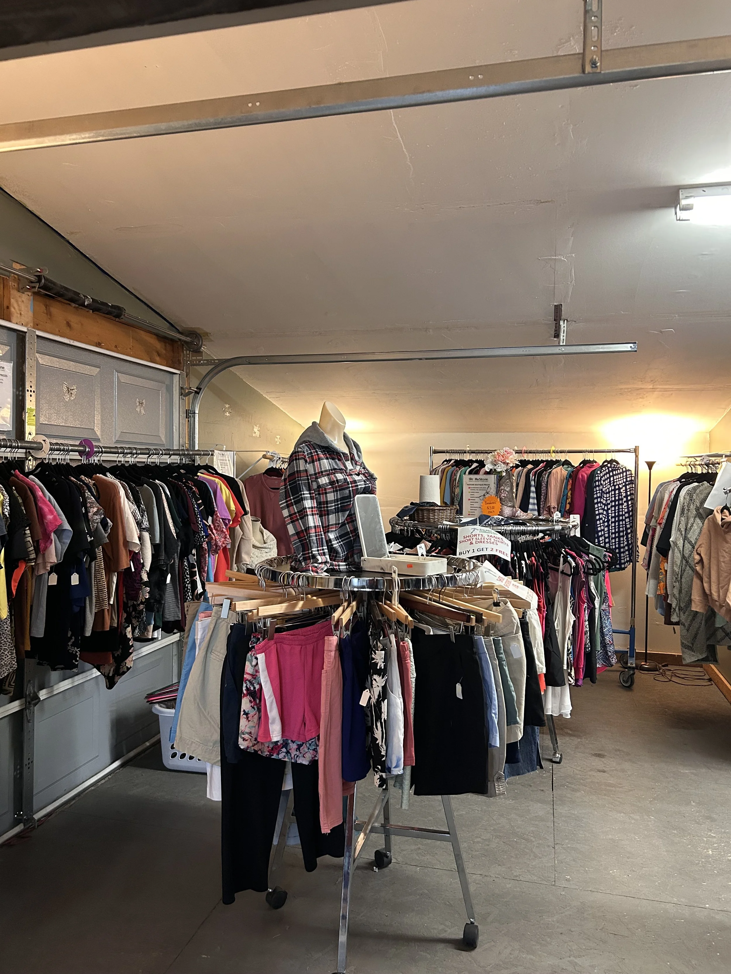 The ReStore's clothing boutique. Hanging clothes on racks.
