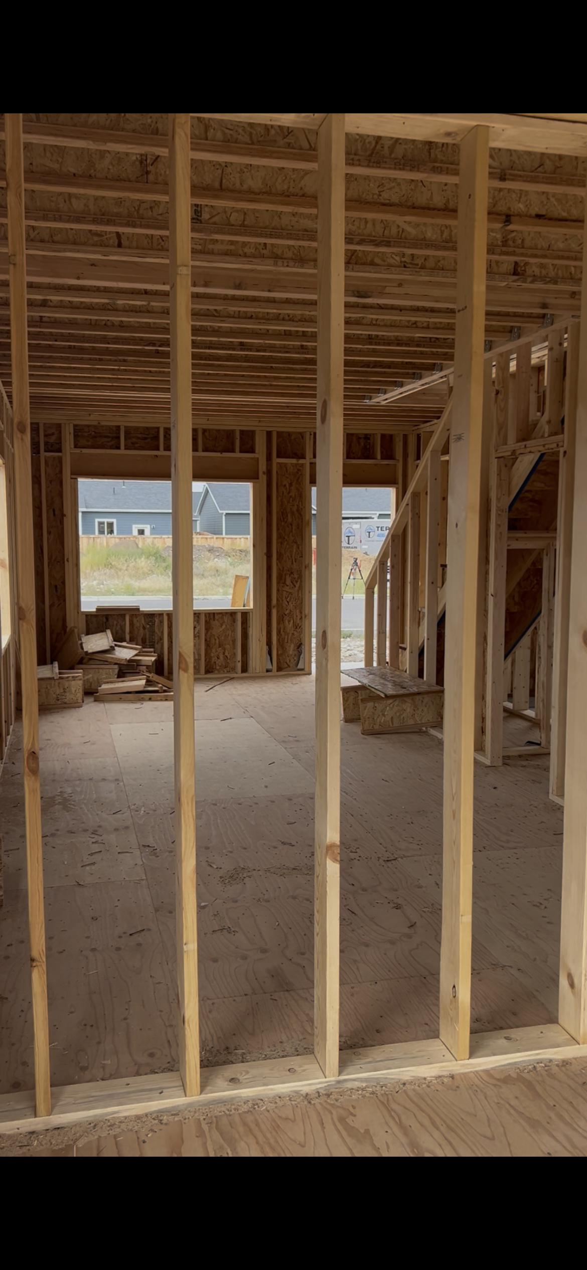 Inside of the framed home showing the living room to be.