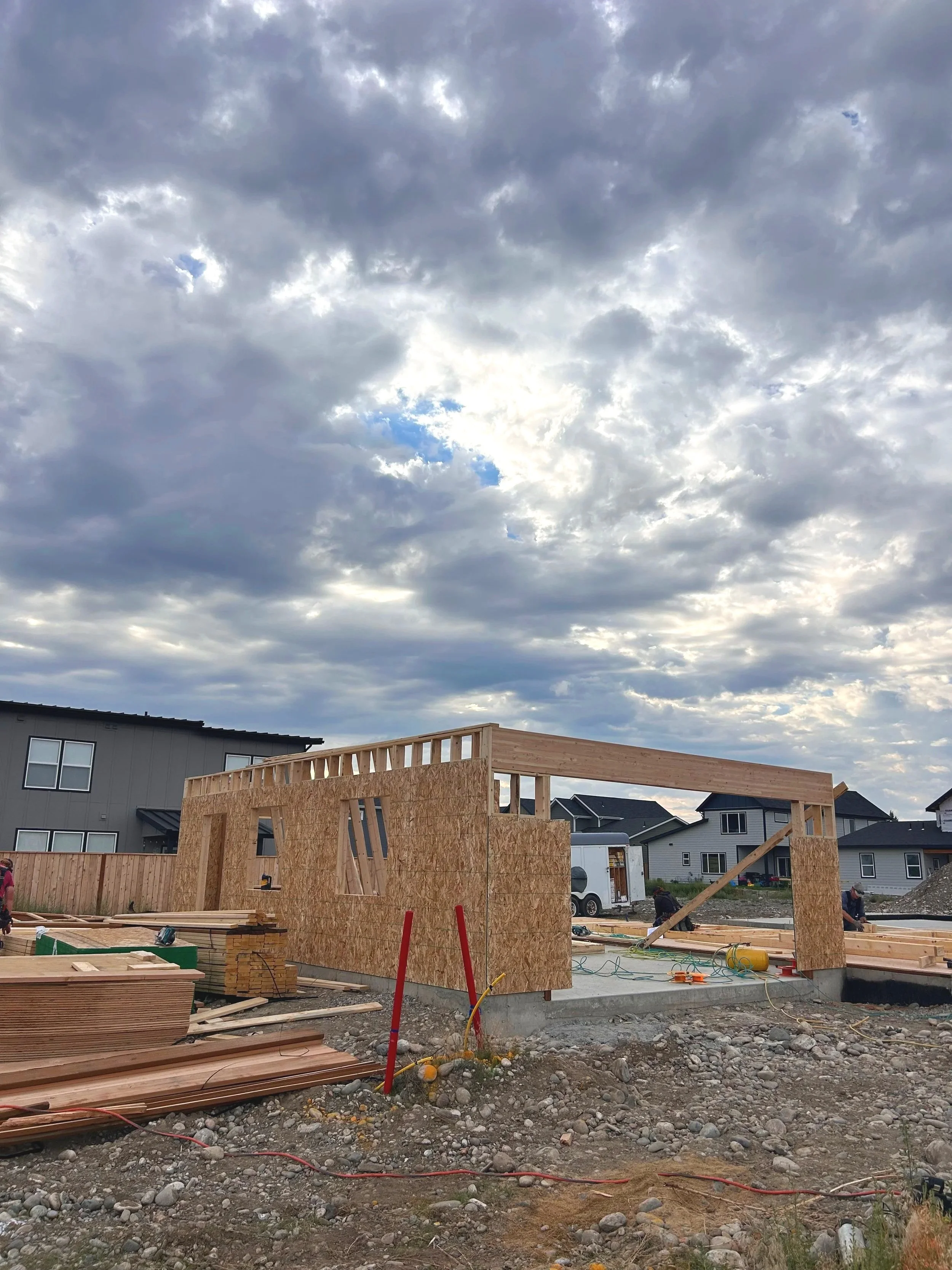 The beginning stage of framing a house. Wooden walls up to enclose the garage.