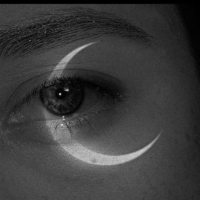 Close-up of a human eye in black and white with a crescent moon shape overlay.