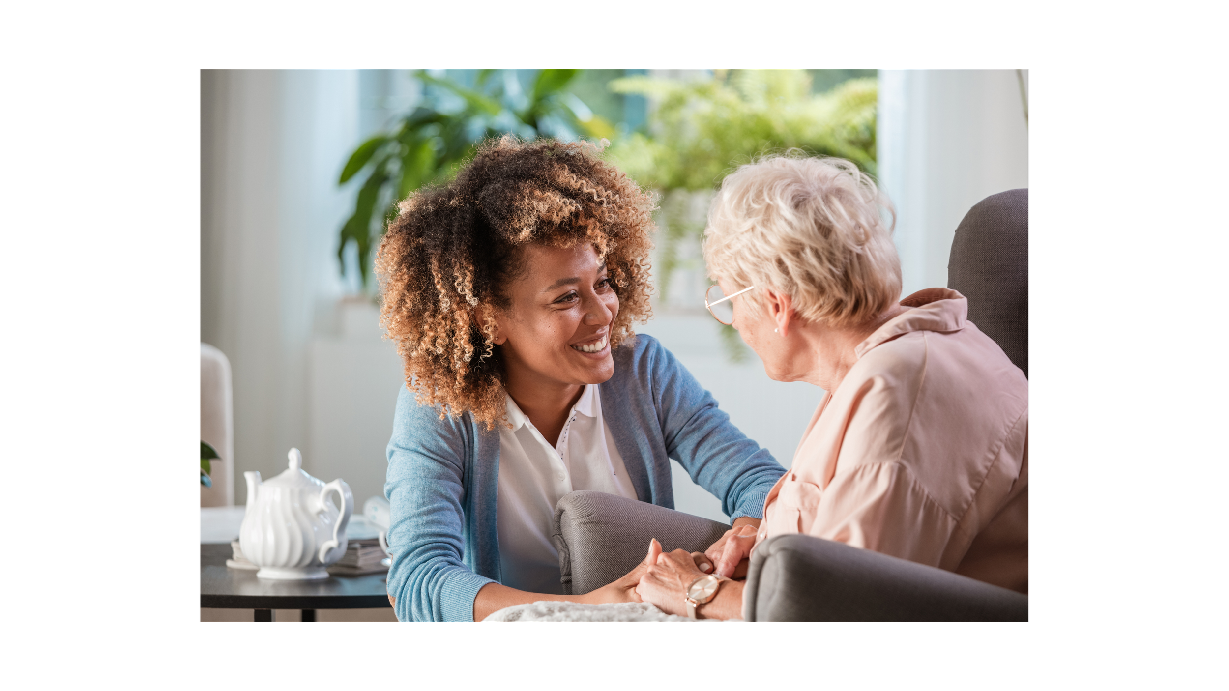 A smiling young woman embracing an older woman's hands