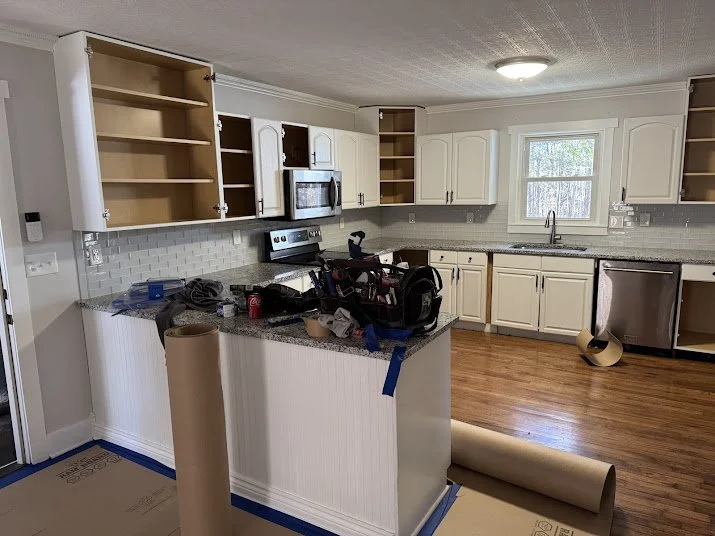 Custom walk-in tile shower with stone floor, waterproofing system, bench seating, and niche built by Saylor’s Home Services.