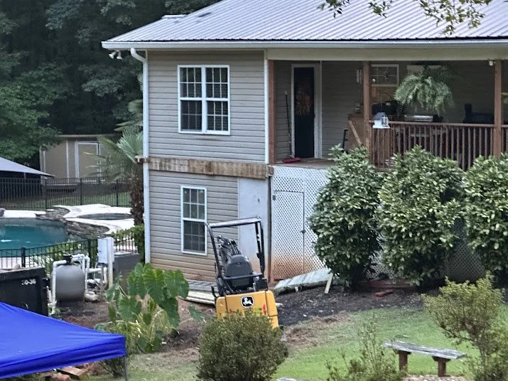 Custom walk-in tile shower with stone floor, waterproofing system, bench seating, and niche built by Saylor’s Home Services.