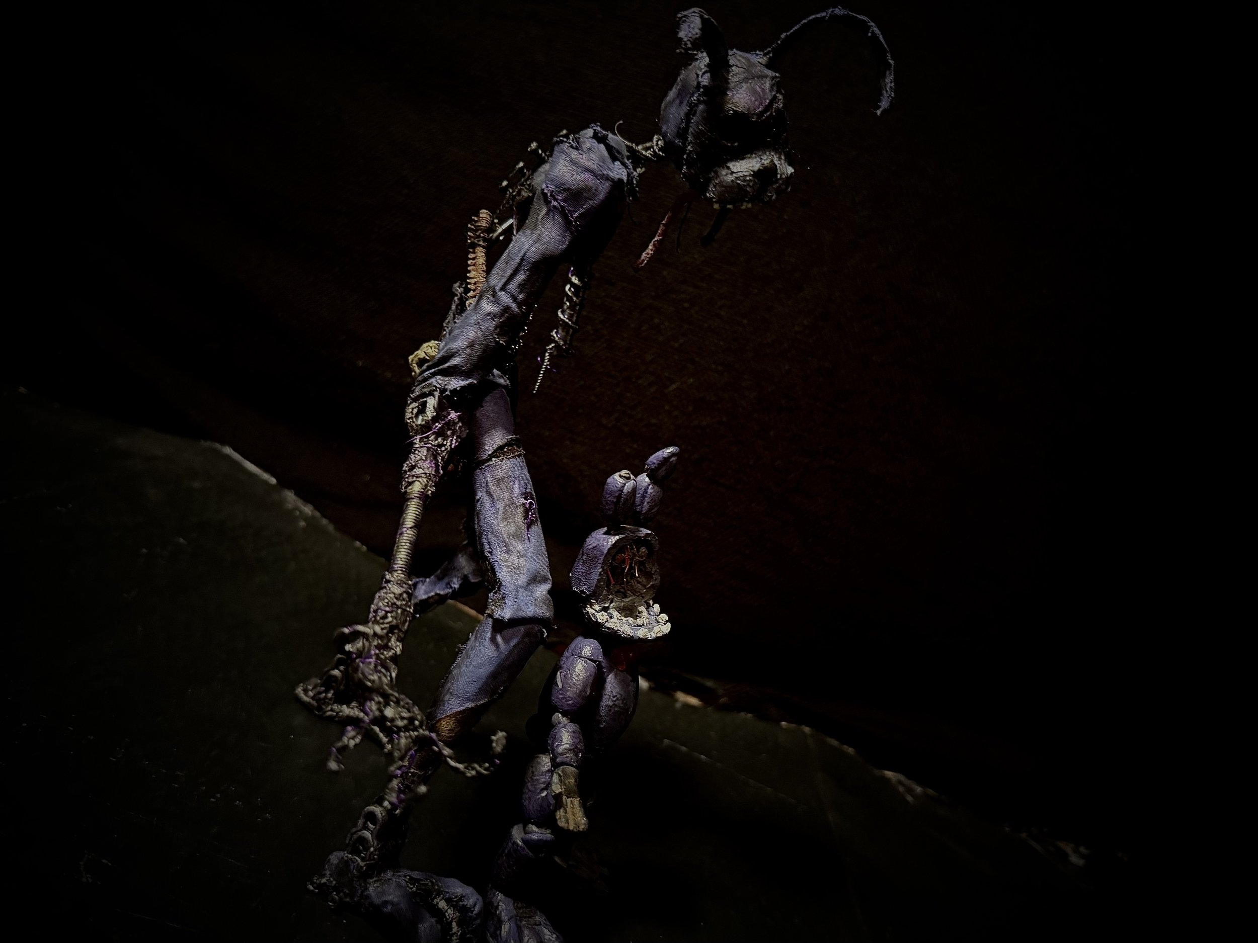 A small humanoid figure with a large head stands beside a tall, dark, skeleton-like creature.