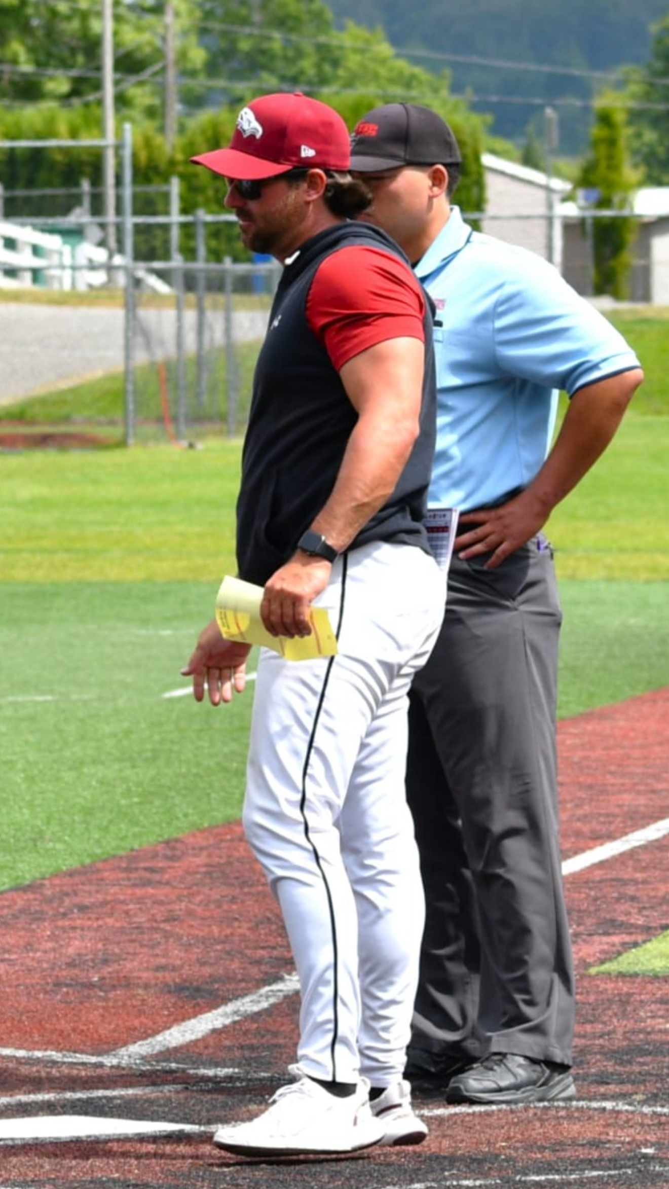 Mitch Davidoff, elite Canadian Baseball coach and Head coach of the Victoria Eagles meets the umpire crew at home plate at the Langley Blaze home field, McLeod Field.