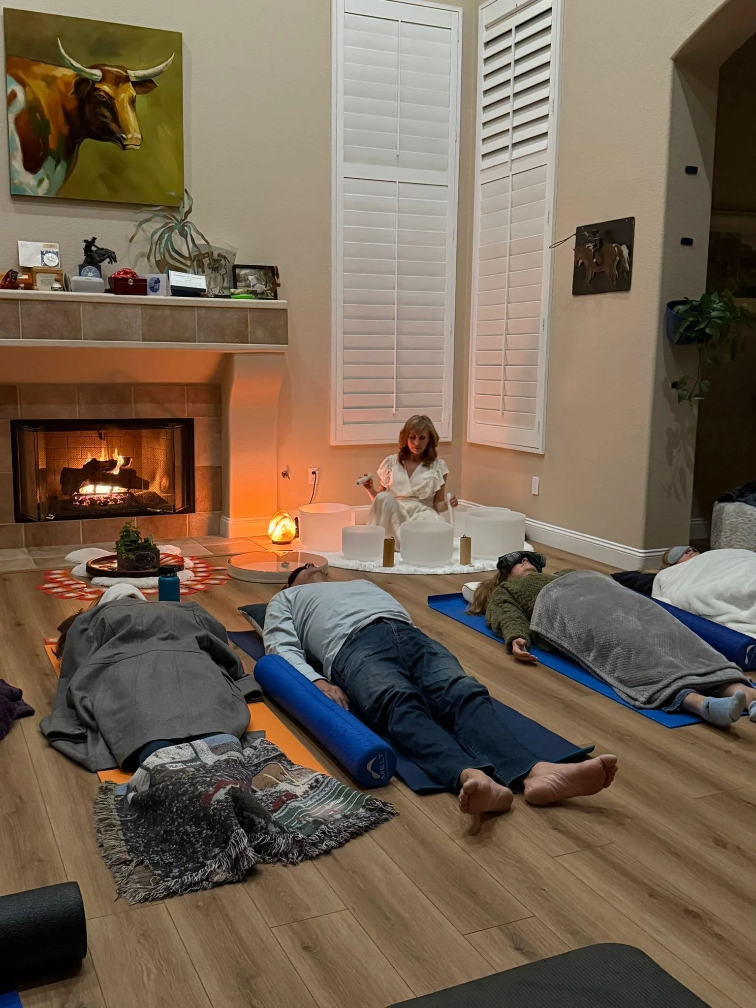 Scenic view of snow-capped mountains behind a green hillside with a modern building in the foreground.